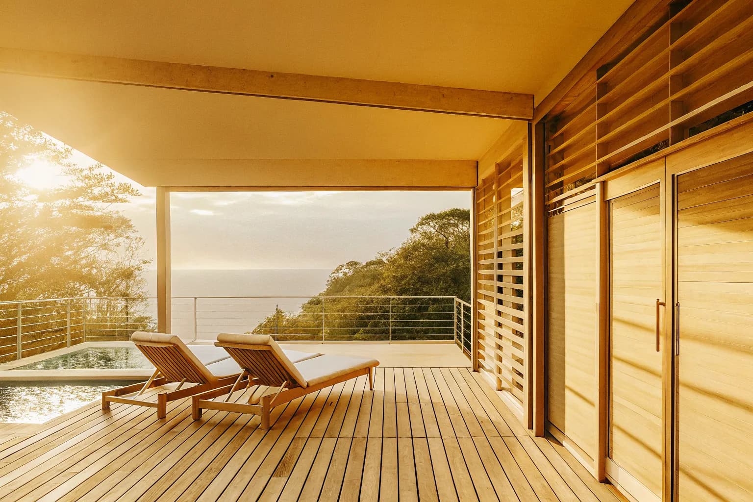 Luxury villa deck with pool overlooking Costa Rica jungle and Pacific Ocean at sunset