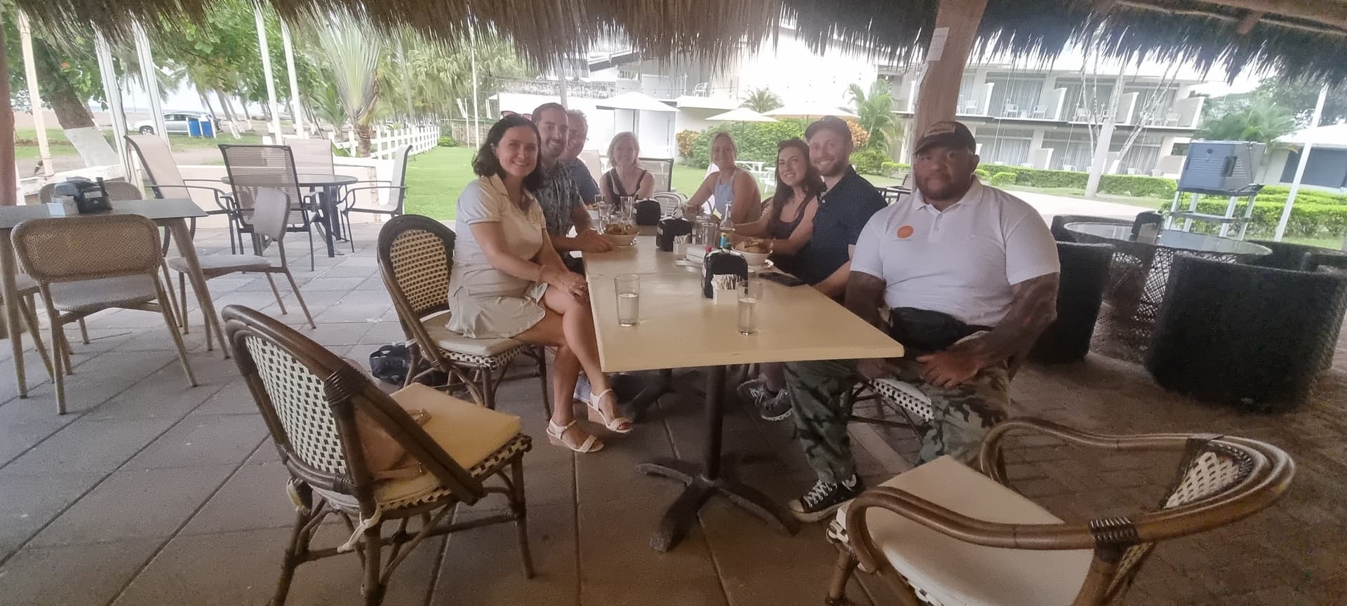 Guests enjoying dining under a beachside palapa in Jacó, Costa Rica