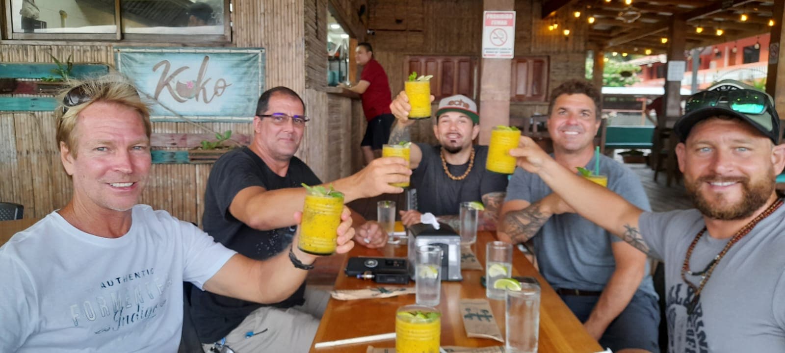 Group of friends enjoying drinks at a local Jacó bar